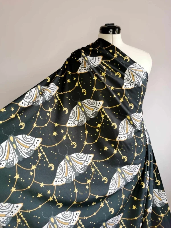 Dark grey witchy moth with moons and stars cotton lycra jersey stretch fabric