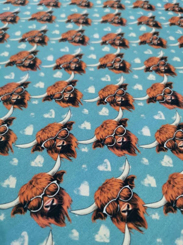 Highland cows on a light blue background with white love hearts, jersey fabric with 4 way stretch