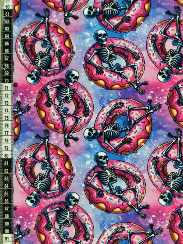 Fun pink skeletons in floating donuts on purple galaxy base, jersey fabric with 4 way stretch