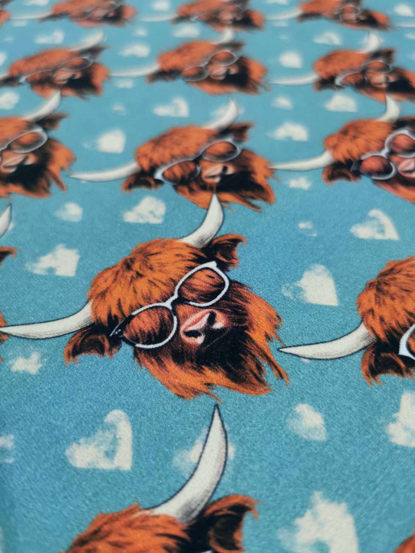 Highland cows on a light blue background with white love hearts, jersey fabric with 4 way stretch