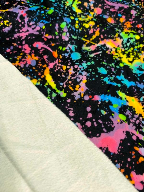 vibrant rainbow Paint splatter design on super soft squish fabric, a stretchy snuggly polyester material.