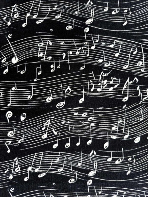 monochrome black and white musical notes dancing across a black background on beautiful quality stretch jersey fabric, perfect for sewing your own clothes.