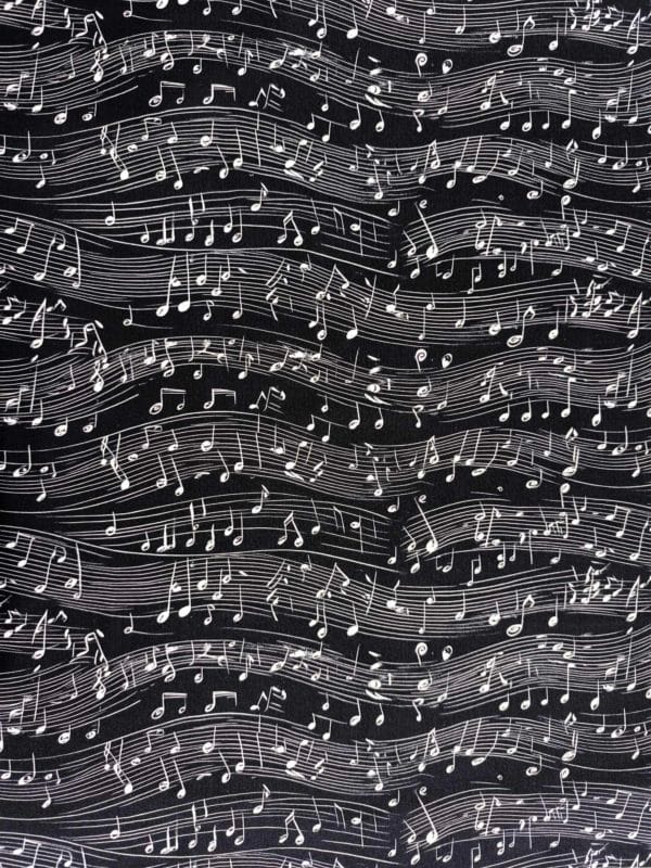 monochrome black and white musical notes dancing across a black background on beautiful quality stretch jersey fabric, perfect for sewing your own clothes.