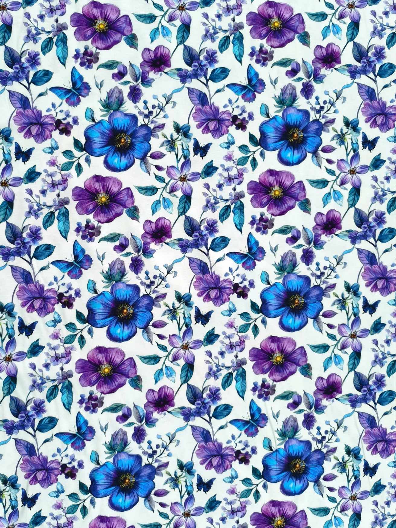 Blue and purple petals and florals, with butterflies on a white background. Jersey stretch fabric base, beautifully soft and stretchy material.