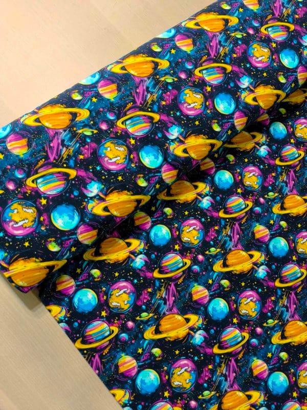 Funky cool planet designs on a dark blue background with purple elements. Jersey stretch fabric base, beautifully soft and stretchy material.