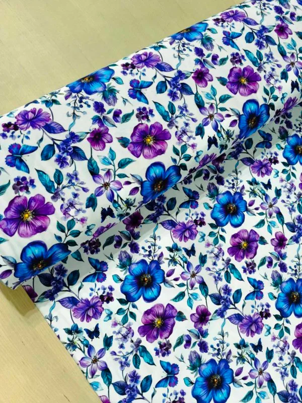 Blue and purple petals and florals, with butterflies on a white background. Jersey stretch fabric base, beautifully soft and stretchy material.