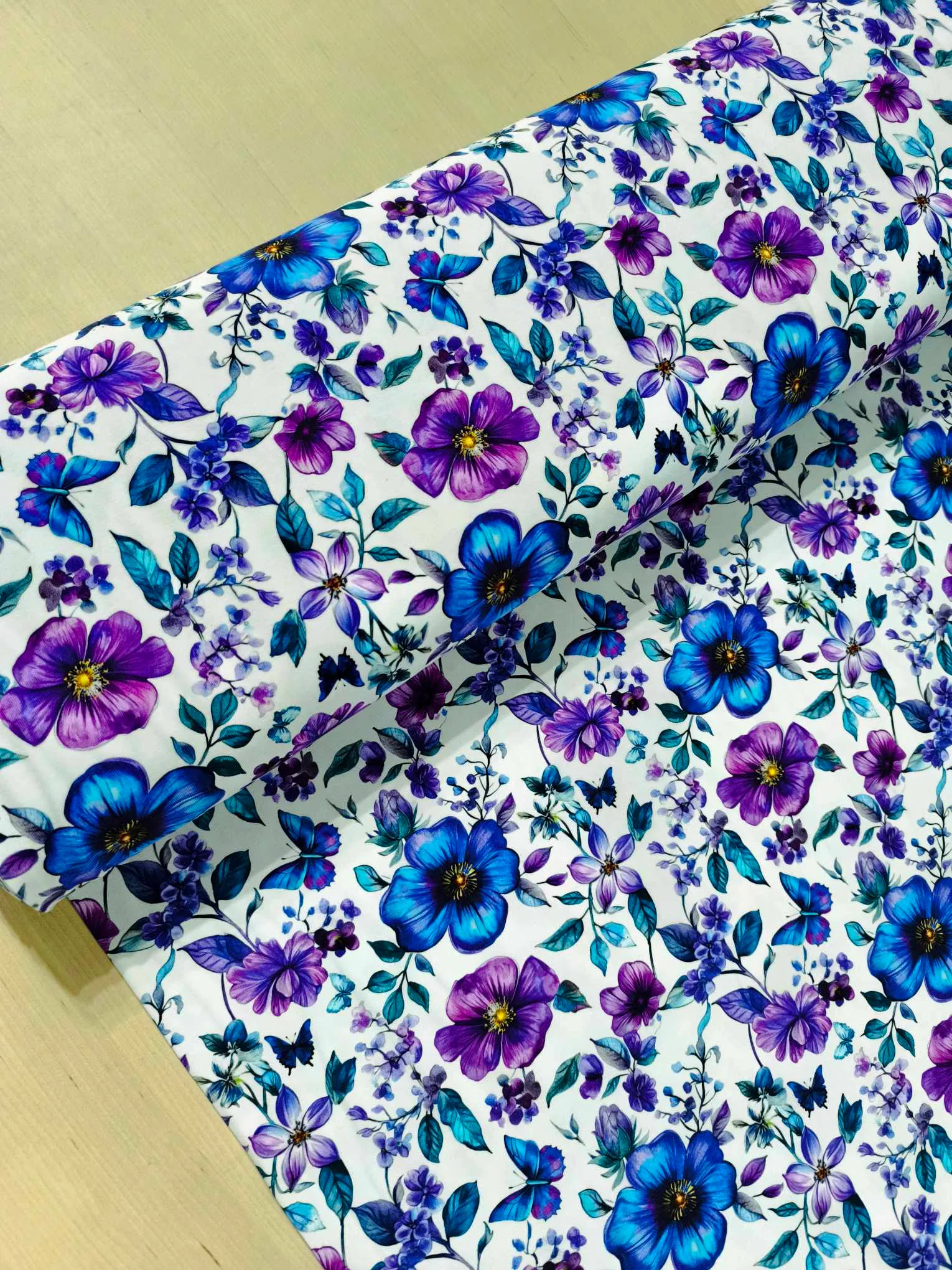 Fresh Floral Jersey Fabric £16.50pm 5 Blue and purple petals and florals, with butterflies on a white background. Jersey stretch fabric base, beautifully soft and stretchy material.
