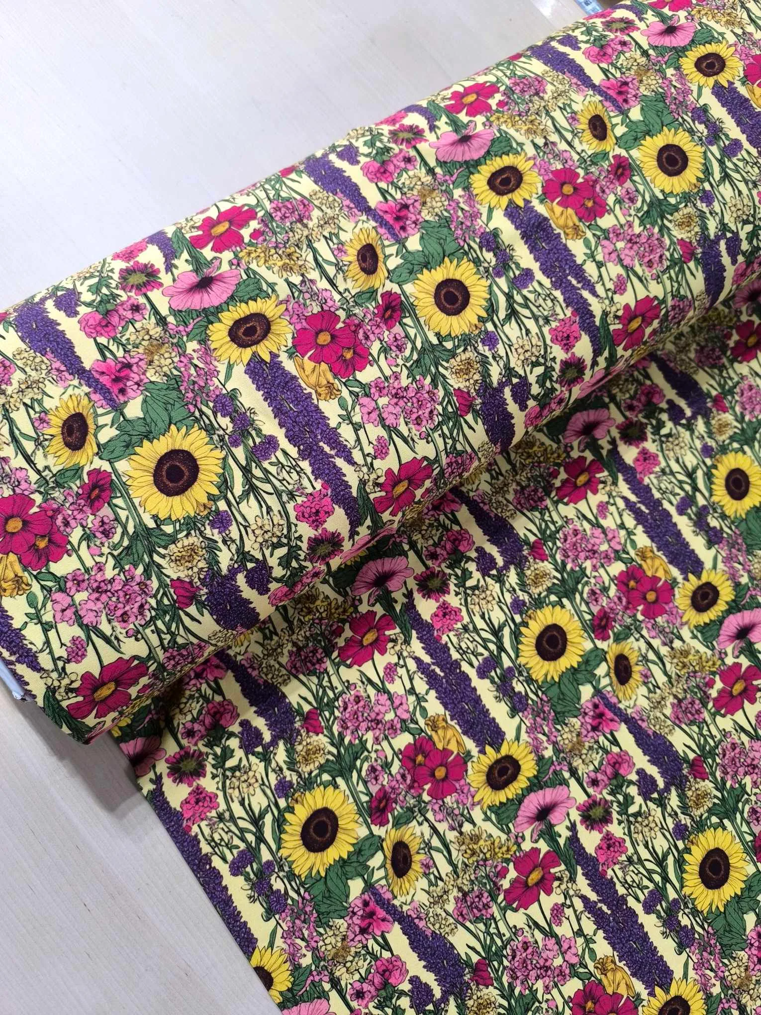 Sunflower and lavendar flowers on a pretty pale yellow base. Jersey stretch fabric base, beautifully soft and stretchy material.